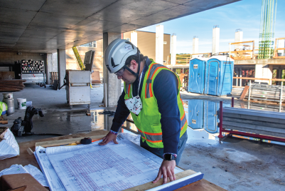 Gabriel Neves checks over final plans as workers set up the concrete pump and prepare for the first of four pours on the building’s fourth and largest floor, which is being built on top of a parking structure. MYAC is scheduled to open in April 2021.