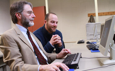 Madison College student Scott Kolar (suit and tie) is learning to weave the Web from instructor Nick Wilkes.