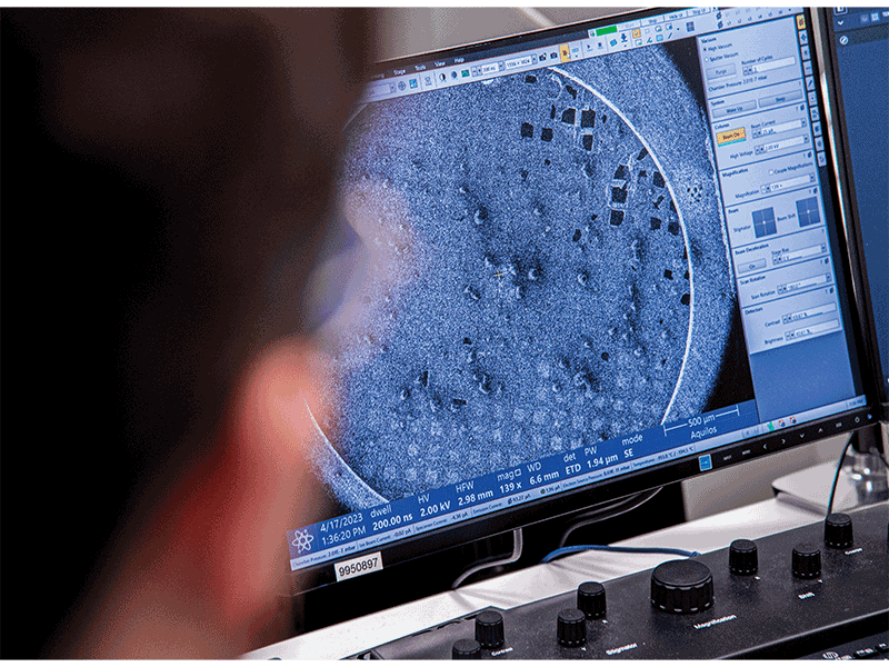 A scanning electron microscopy (SEM) image of a frozen landscape of HeLa cells cultured on a cryo-EM grid. Using a specialized microscope from Thermo Scientific, scientists mill away portions of cells to produce