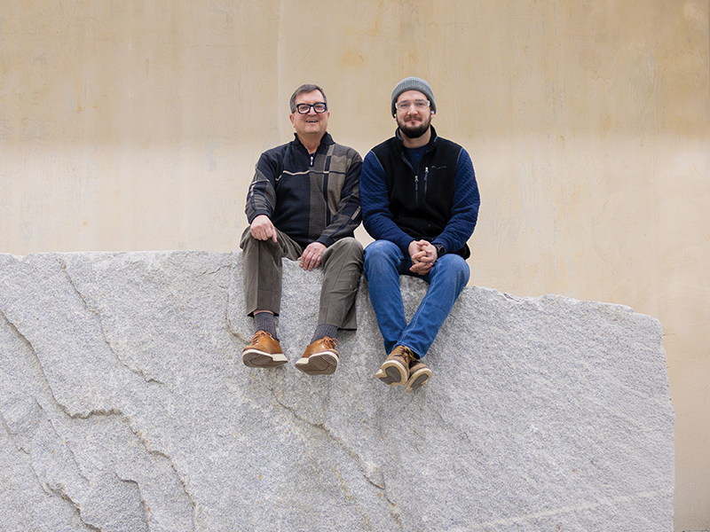 Jim Durham (left) and son Lincoln sit atop one of the 50-ton blocks of stone at Quarra Stone’s new and expanded facility in Sun Prairie.