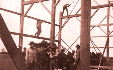 Michael Simon (top, swinging sledgehammer) started his family’s construction business in 1893. At the time, he worked on barns, farm buildings, and homes for $1 a day.