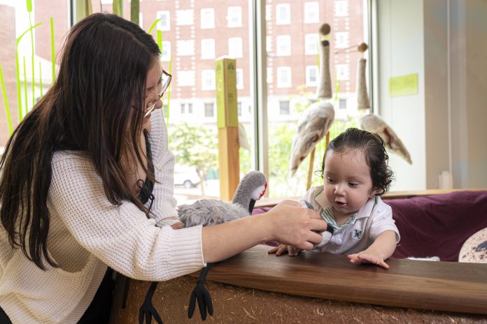 A parent plays with her baby in the Nice Age Trail exhibit at Madison Children’s Museum.