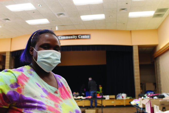 Jazzman Brown, the 2021 recipient of the “Outstanding Individual Achievement Hero Award” from the Boys & Girls Clubs of Dane County, leads a group of volunteers during the “Essentials Giveback” event at the East Madison Community Center in March. (Photo by Kimberly Hazen)