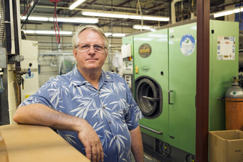 Best Cleaners owner John Whitley, in front of his dry-to-dry machine, says most people don’t know that every dry cleaner will clean the American flag for free.
