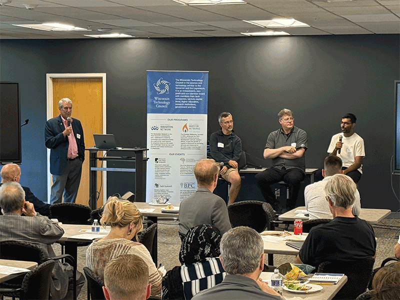 As Wisconsin Technology Council President Tom Still looks on, Remzi Arpaci-Dusseau, the director of UW-Madison's school of Computer, Data & Information Sciences, Google's Milo Martin and Microsoft's Shaleen Deep discuss ties between academia and industry at a Tech Council lunch on Tuesday at One City Schools.