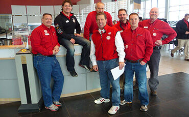 Members of the Smart Motors staff show off their casual shoes during last year’s Suits and Sneakers Challenge.