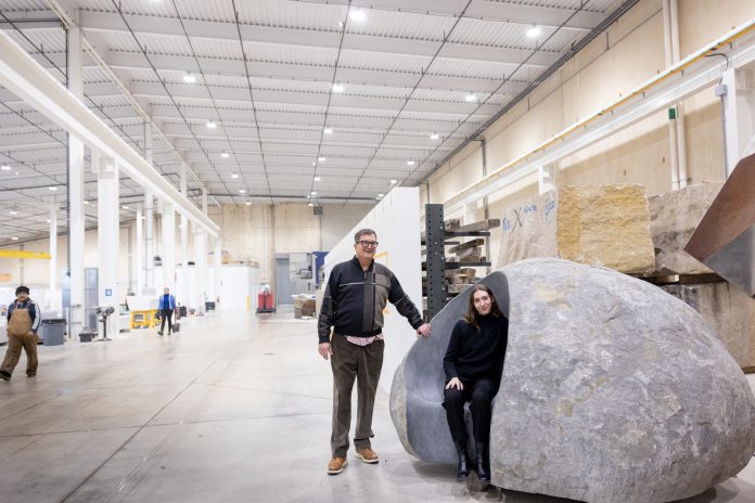 Olivia Wrobleski, executive assistant to Quarry Stone founder Jim Durham (left), finds a stone carveout to relax in at the company's facility in Sun Prairie.
