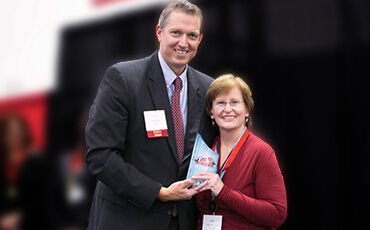 Sally Greenwood receives her Get Fit Challenge “Most Improved Woman” trophy from IB Publisher Jon Konarske.