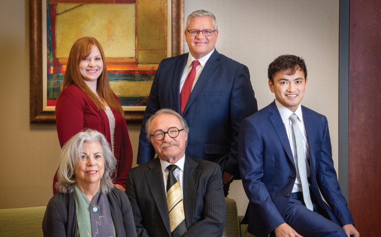 After a year of pandemic relocation, the staff of Custer Financial Services has returned to their Madison office. Standing are Kaitlyn Senn and Earle Smith. Sitting are Betty Harris Custer, J. Corkey Custer, and Alex Thairuammit. (Photo by Bill Fritsch)