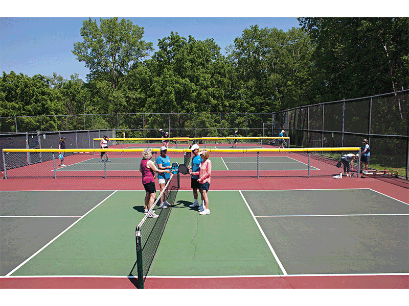 At Garner Park, home to the only dedicated pickleball courts in Madison, Nancy Ketterhagen, Dan and Martha Larson, and Mary E. tap paddles at the end of a