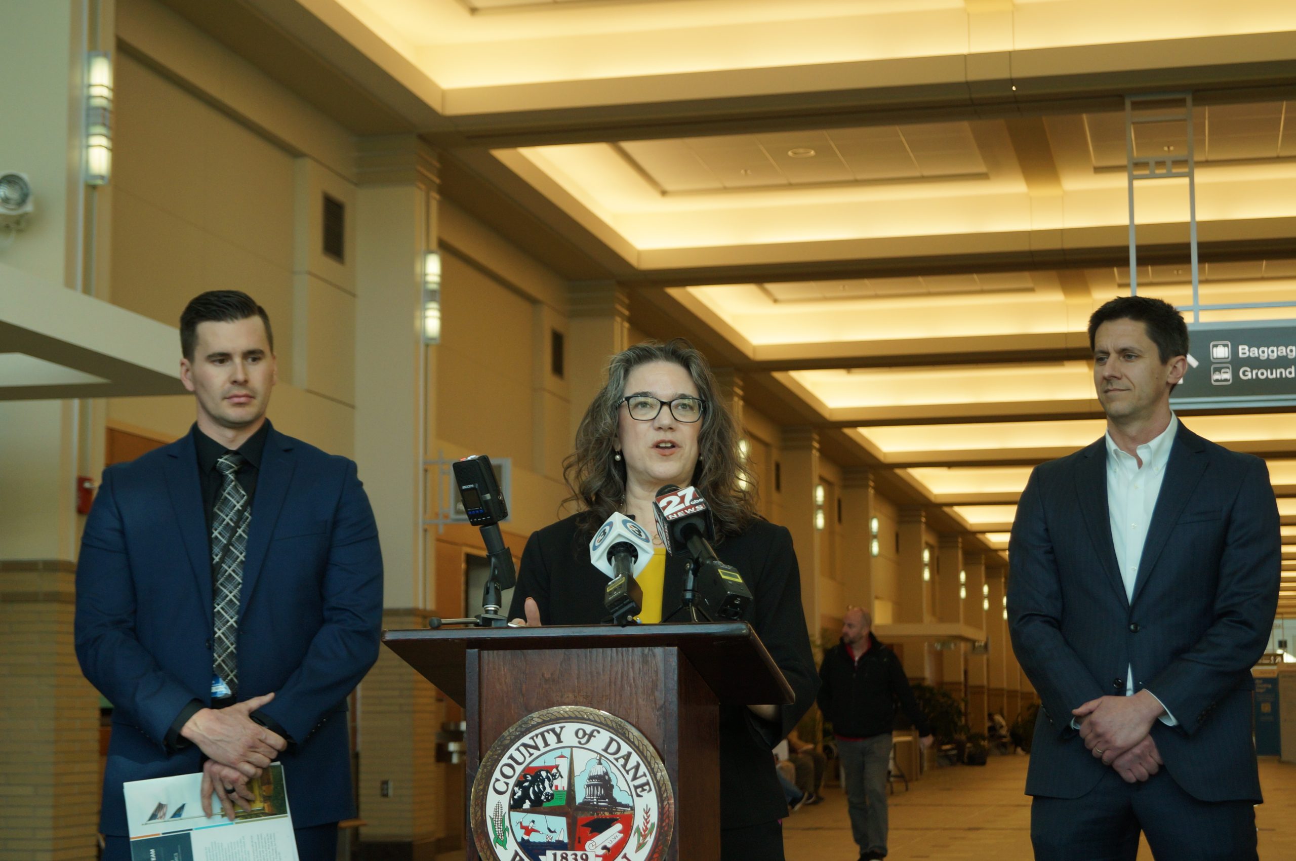 From left: Dane Country Regional Airport director Mark Papko, Dane County Executive Melissa Agard and Greater Madison Chamber of Commerce Vice President Kevin Little present economic impact information at a Feb. 18, 2026, media event.