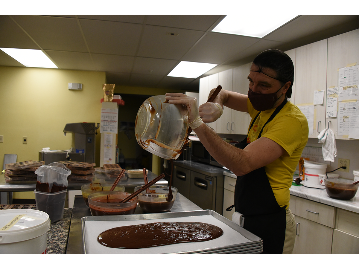 Gail Ambrosius Chocolatier staff member Derek Hain makes a single-origin Guatemalan dark chocolate ganache for truffles.