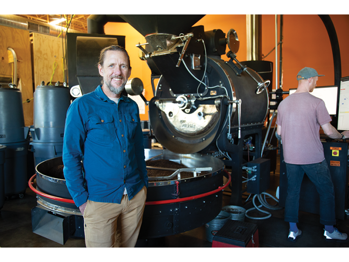Wonderstate co-owner TJ Semanchin stands in front of a 90-kilo Probat coffee roaster from the 1950s during a roast.