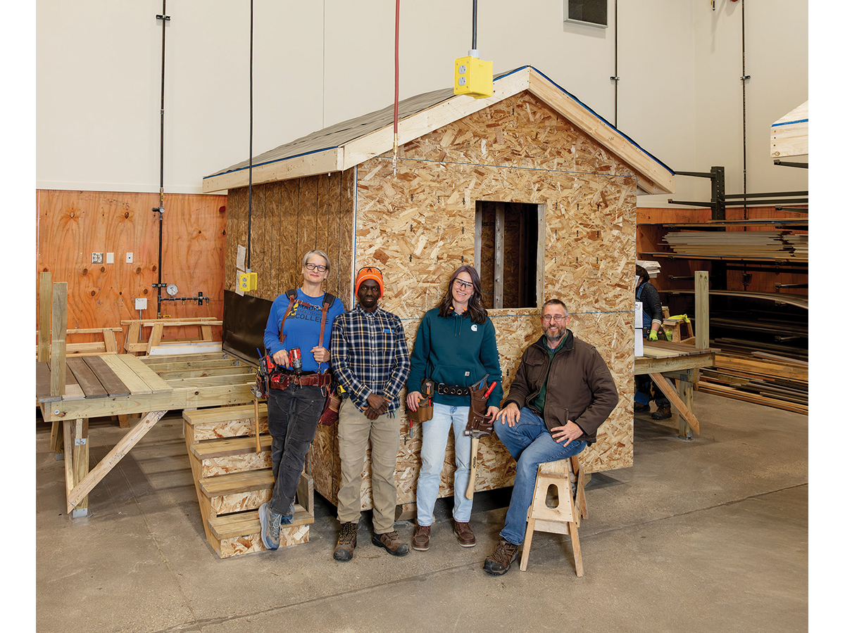 (L-R) Instructor Sandra Thistle, graduate Rogers Senteza, student Stephani Dalbesio and contractor Tony Trapp gather in front of one of the program's tiny homes.