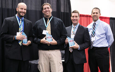 Curtis Hall, Matthew Reller, Matt Anderson, and Taylor Key show off their Get Fit Challenge trophies at the In Business Expo & Conference.