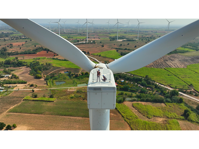 Electrical engineers atop a wind turbine that generates electricity for the grid.