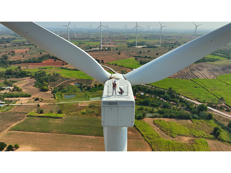 Electrical engineers atop a wind turbine that generates electricity for the grid.