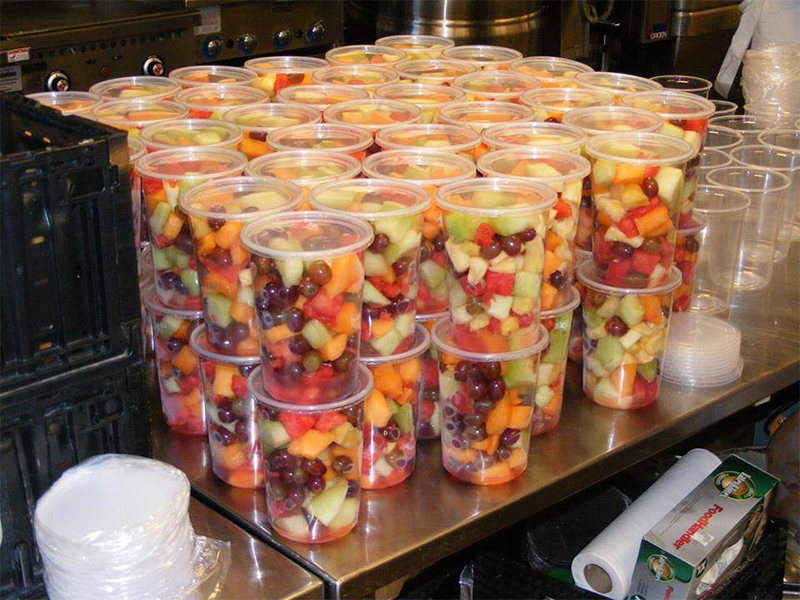 Repackaged fresh fruit salad from Epic's annual Users Group Meeting is prepared in family-sized portions and ready for distribution.
