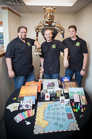 J.T. Smith, Jamie Vrbsky, and Tavis Parker in a rare moment together. Cog, their self-built company icon, stands 8 feet 3 inches tall, weighs 630 pounds, and impresses crowds at trade events.