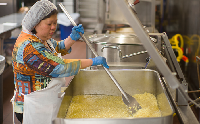 Josey Chu, proprietor of Madame Chu, a local producer of special Southeast Asian delicacies, prepares her Ginger Garlic sauce at FEED Kitchens. Chu says she has depended on counsel from SCORE Madison advisers to grow her business “in the right way.”