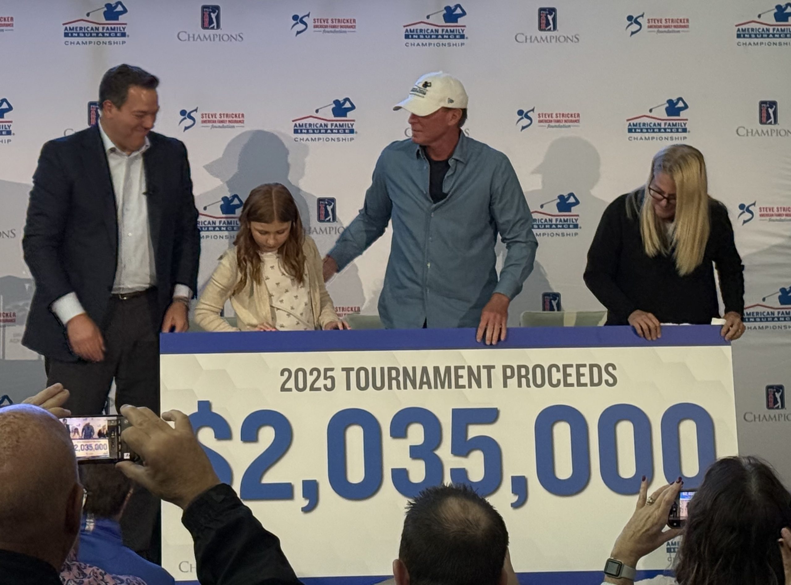 (From left) American Family Insurance CEO Bill Westrate, eight-year-old cancer survivor Laine Meske, tournament host and player Steve Stricker and his wife Nicki Stricker unveil this year's AmFam Champ proceeds.