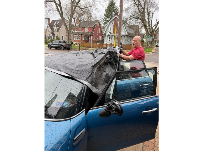 John Stevenson covered his car with a tarp after hail smashed his sunroof.