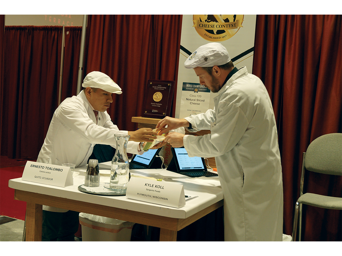 Judges Ernesto Toalombo and Kyle Koll judge some Tillamook cheese in the natural sliced cheese category at the World Championship Cheese Contest on March 4.
