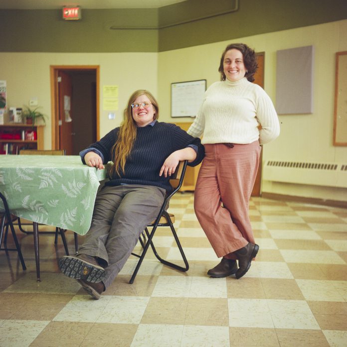 Program coordinator Rachel Peller, right, and her wife, building coordinator Rebecca Krausert Sykalski, pose for a portrait at Merrimac and Main, Jan. 13, 2026, in Dodgeville, Wis. (Joe Timmerman / Wisconsin Watch)