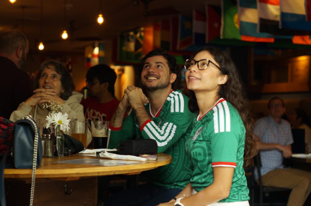 Two donning Mexico jerseys watch the opener of the 2026 World Cup between Mexico and South Africa on June 11 at The Coopers Tavern.