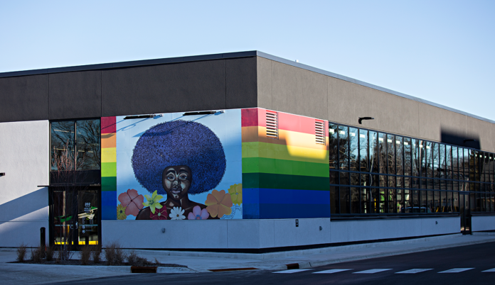 A mural of someone with an afro on the side of a black building