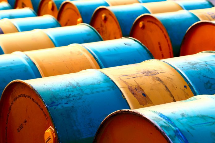 Dozens of blue and yellow oil barrels