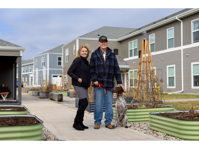 Diana Kaschinske, Poynette village president, joins developer Randy Alexander and his dog Atticus outside of Point Gardens' apartments.