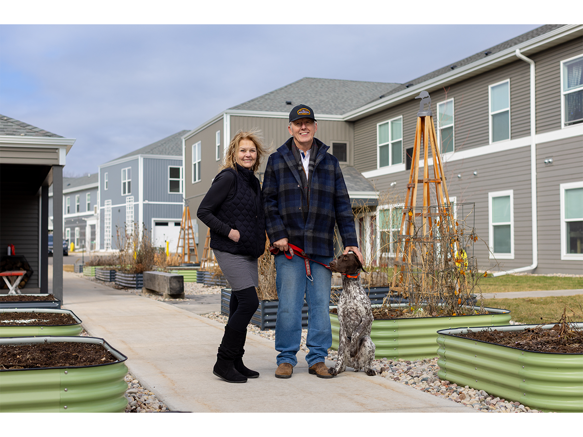 Diana Kaschinske, Poynette village president, joins developer Randy Alexander and his dog Atticus outside of Point Gardens' apartments.