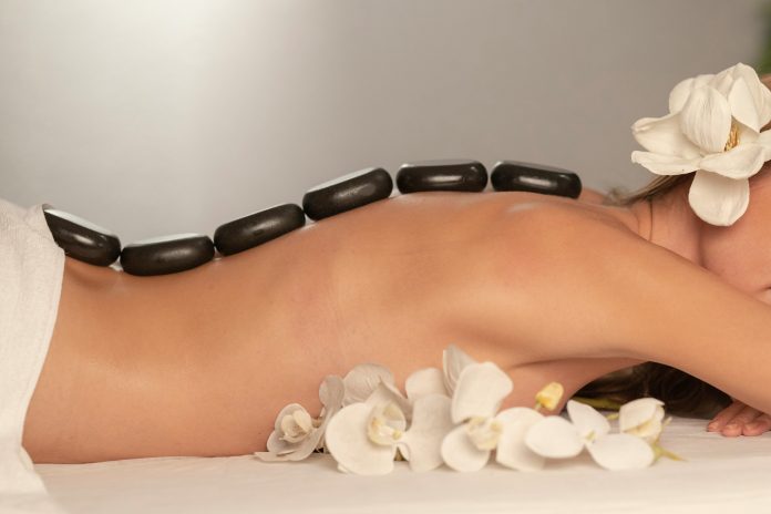 A woman with rocks on her back during a massage