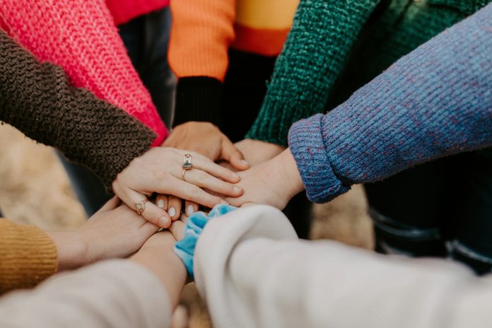 A group putting their hands together in a huddle