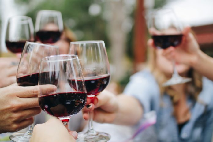Glasses filled with red wine being used for a cheers