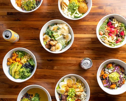 Bowls of salads on a brown wooden table