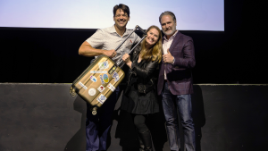 Pressure Chamber winner Strudel (Brian Kaufman, Kristin Isaac) receive the 2025 golden suitcase from GMCC President Zach Brandon.