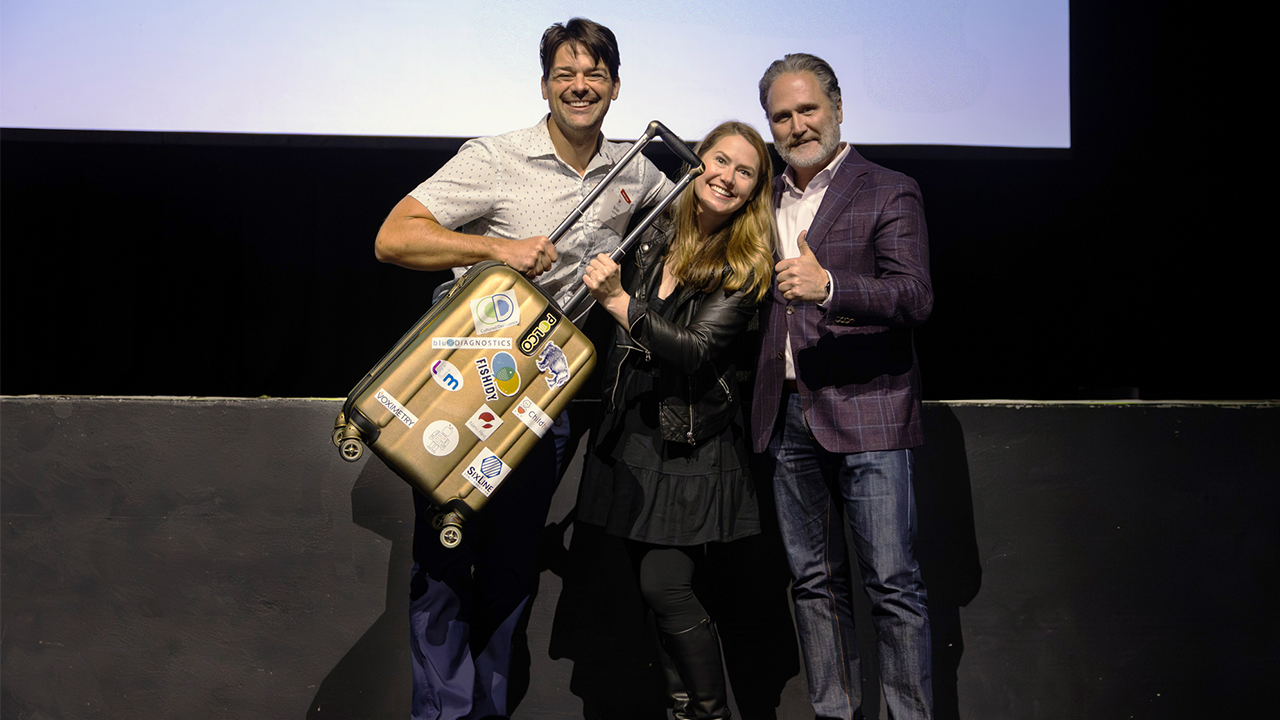Pressure Chamber winner Strudel (Brian Kaufman, Kristin Isaac) receive the 2025 golden suitcase from GMCC President Zach Brandon.