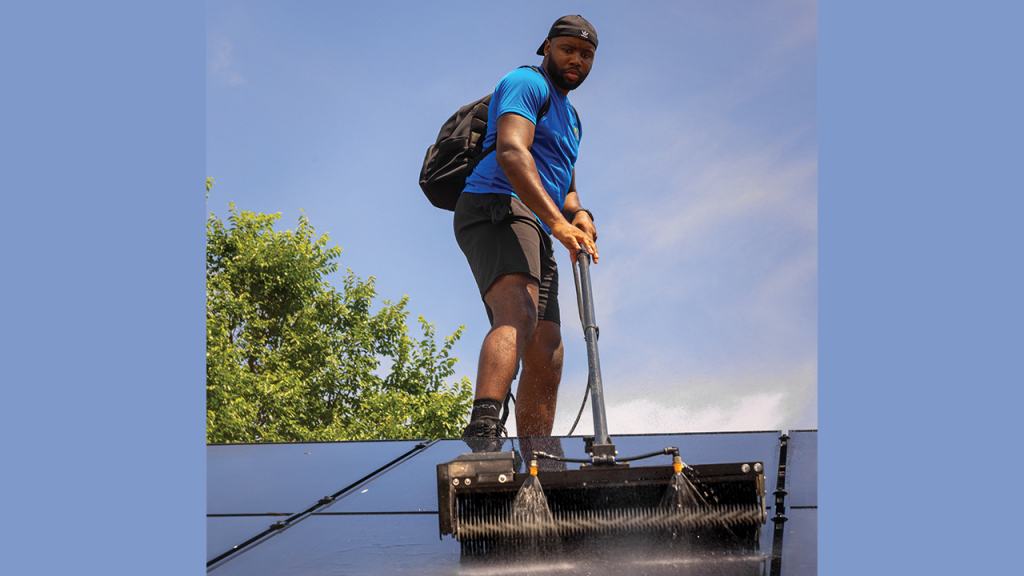 Solar Alchemist's Marquis Mason keeps solar panels clean to optimize energy output.