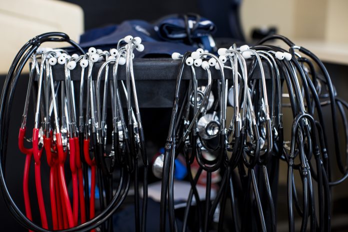 Red and blue stethoscopes hang on a bar