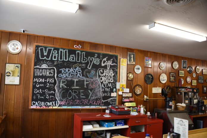 A chalk board in a cafe with menu items and a message about Corey Ruiz's death.