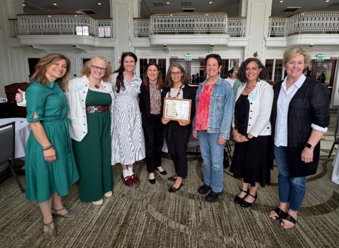 A group of ladies with one holding an award certificate