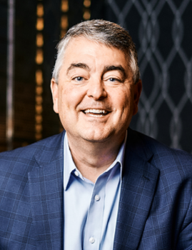 Lake Ridge Bank President Paul Hoffmann poses for a portrait in a blue jacket and light blue shirt