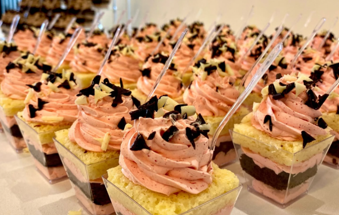 A row of baked goods with pink frosting