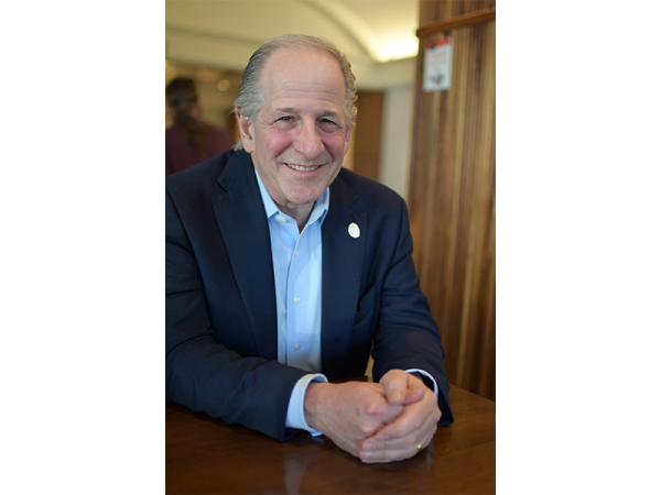 Greg Marcus, a man, sits at a table