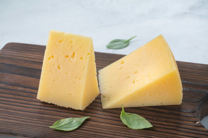 Two pieces of slightly yellow cheese wedges