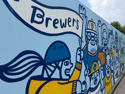 A blue and yellow mural featuring fans of the Milwaukee Brewers