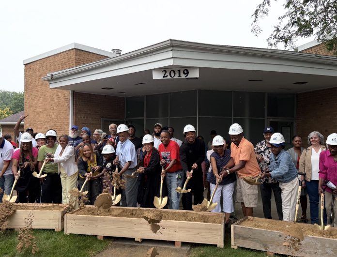 A group of people in hard hats shoveling dirt