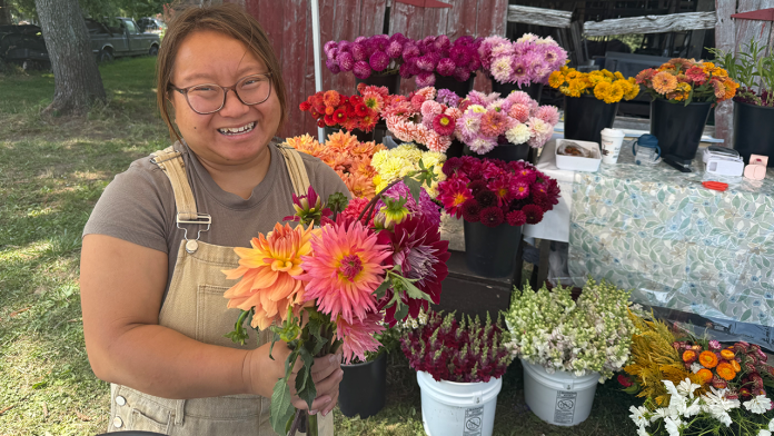Cher's Garden is a family operation. Cher's daughter Kathie Yang holds a bouquet of just-picked dahlias. Photo: Katie Dean